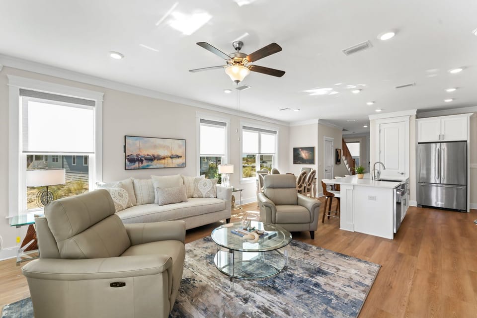 Relax in your bright, modern living space with comfortable seating, open kitchen, and warm wood floors perfect for unwinding.
