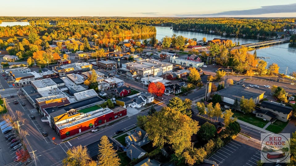 A sweeping aerial view looking toward Lake Minocqua and the bridge, highlighting the cottage’s desirable island location.