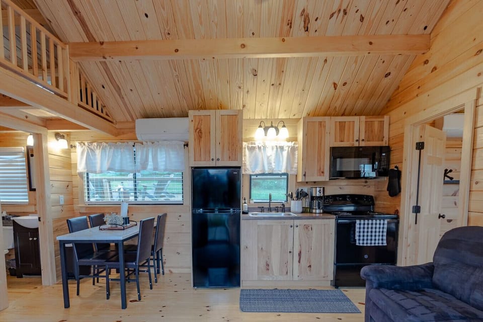 Open dining table & kitchen layout beneath warm wood ceilings