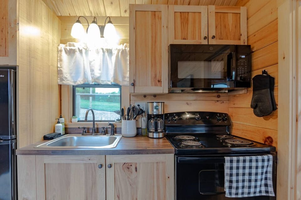 Well-equipped kitchen w/ stove, microwave & window bringing in daylight