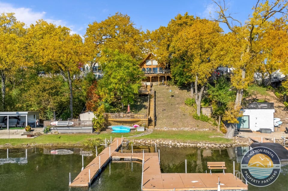 Your private lakefront retreat comes into view, offering direct access to the water and your own dock. Enjoy lake days with a canoe, two standup paddleboards, and a propane fire table for relaxing evenings by the shoreline.