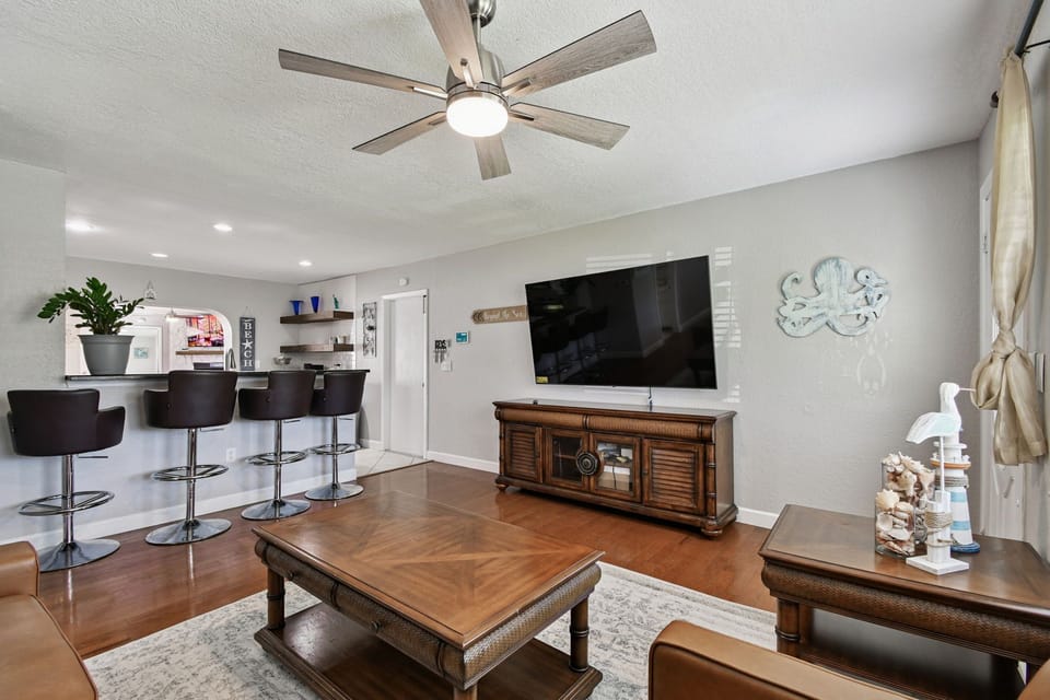 Gather in the spacious living room with a huge flat-screen TV, offering the perfect setup for family movie nights or relaxing after a day of exploring Pinellas Park and nearby attractions.