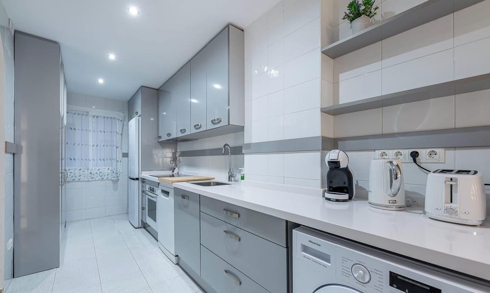 Modern kitchen with gray cabinets, white countertops, and essential appliances.