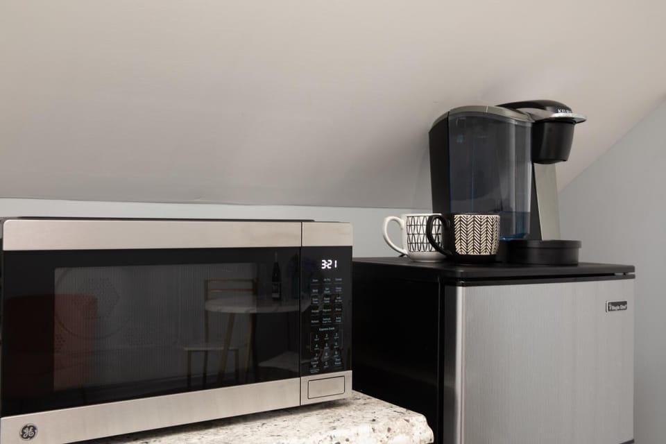 Compact kitchenette with microwave, mini-fridge, and coffee maker.