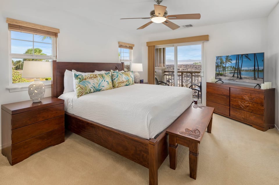 King primary bedroom with smart TV and ceiling fan