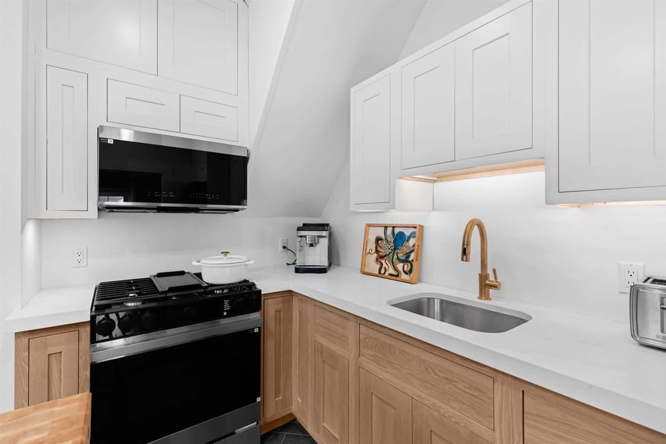 High-end stainless steel appliances, including a stove and built-in microwave, elevate every culinary experience.