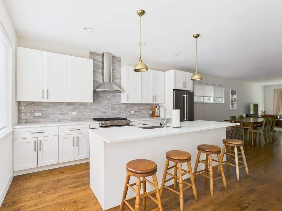 Bright, fully equipped chef’s kitchen featuring quartz counters, brass accents, and everything you need to cook or entertain.