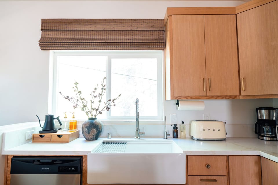 Bright kitchen with deep farmhouse sink, SMEG toaster, and all your cooking needs.