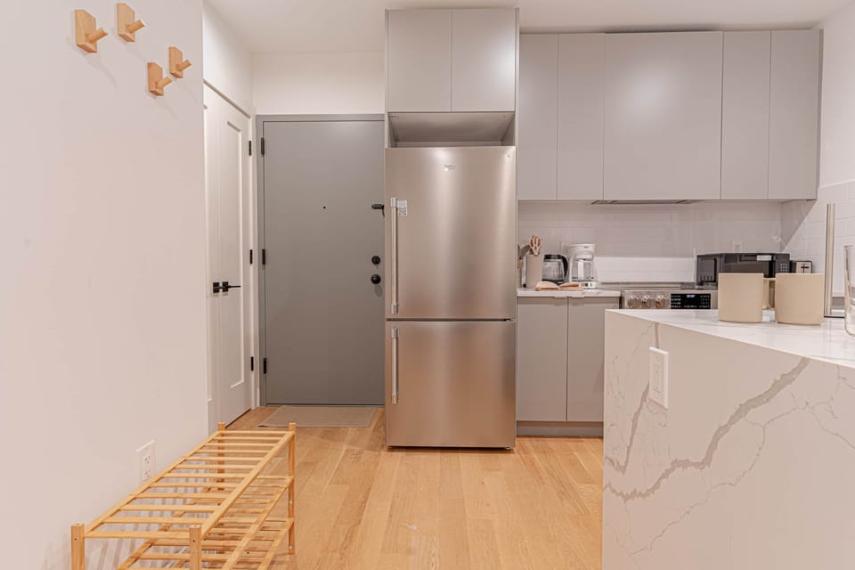 Full-size refrigerator and freezer combo keep groceries fresh during extended stays in Brooklyn.