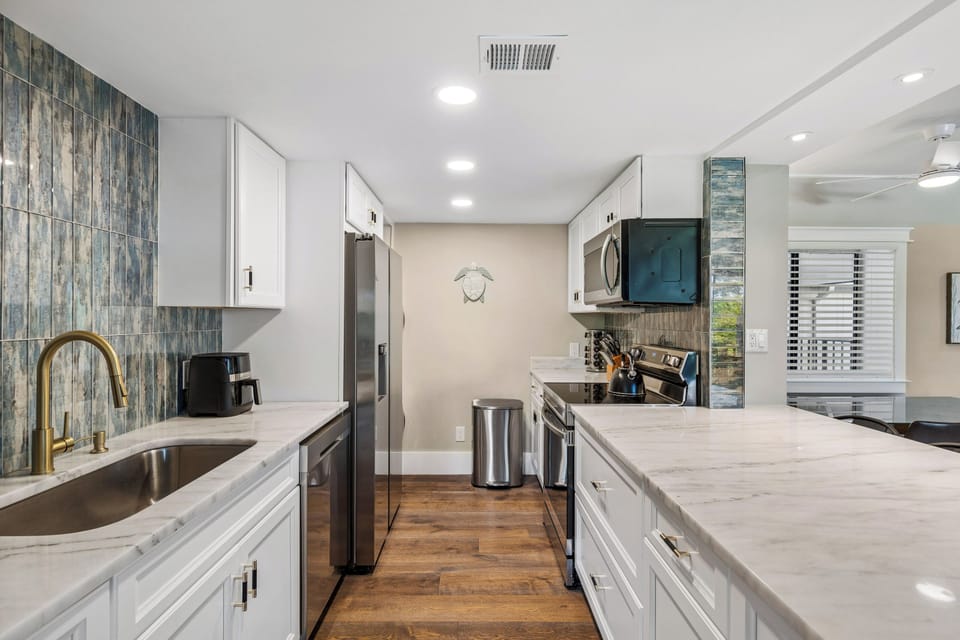 Fully stocked kitchen with stainless steel appliances and 4 barstools for extra seating.