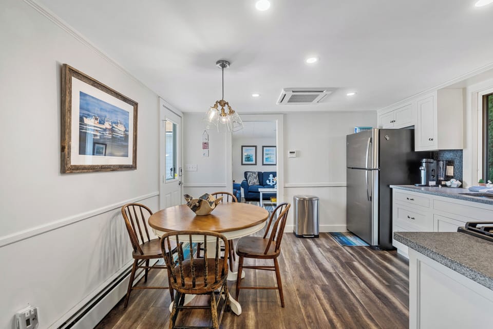 Bright and open dining area with a cozy table for four, seamlessly connected to a fully equipped kitchen—perfect for shared meals and easy gatherings.