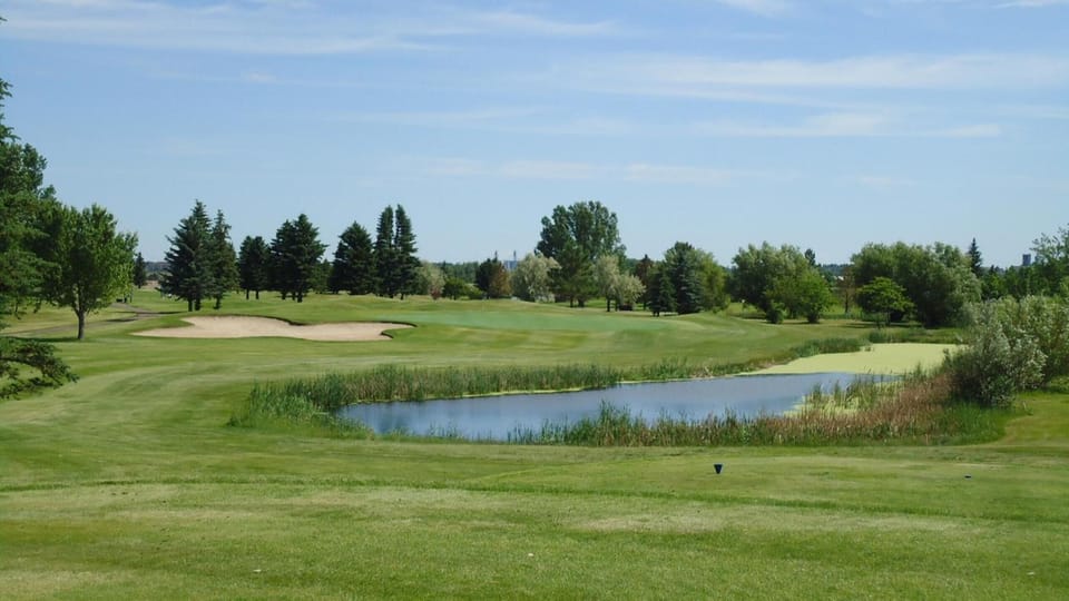 Unwind with serene pond views beside lush greens.