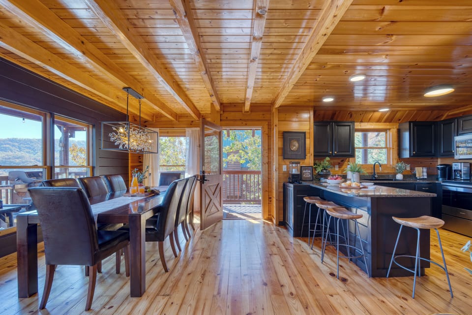A warm, open kitchen and dining area with mountain views, perfect for shared meals and cabin-style gatherings.