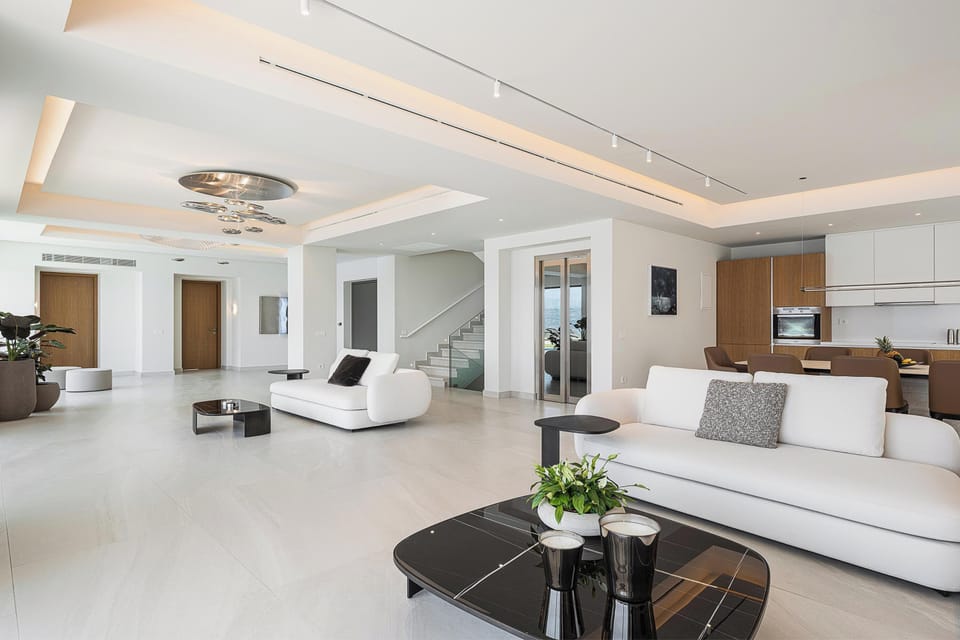 The living room’s plush furnishings and subtle lighting invite guests to relax