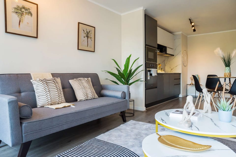 Stylish and cozy living area with modern decor and a compact kitchen, perfect for relaxing and dining in comfort.