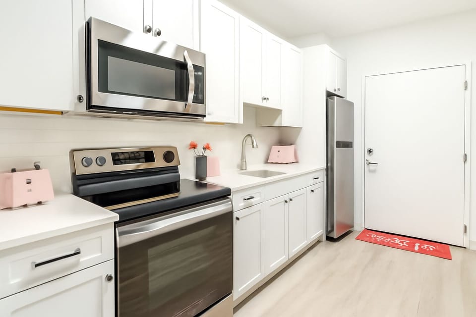Fully equipped for your stay, complete with modern appliances in a pink aesthetic.