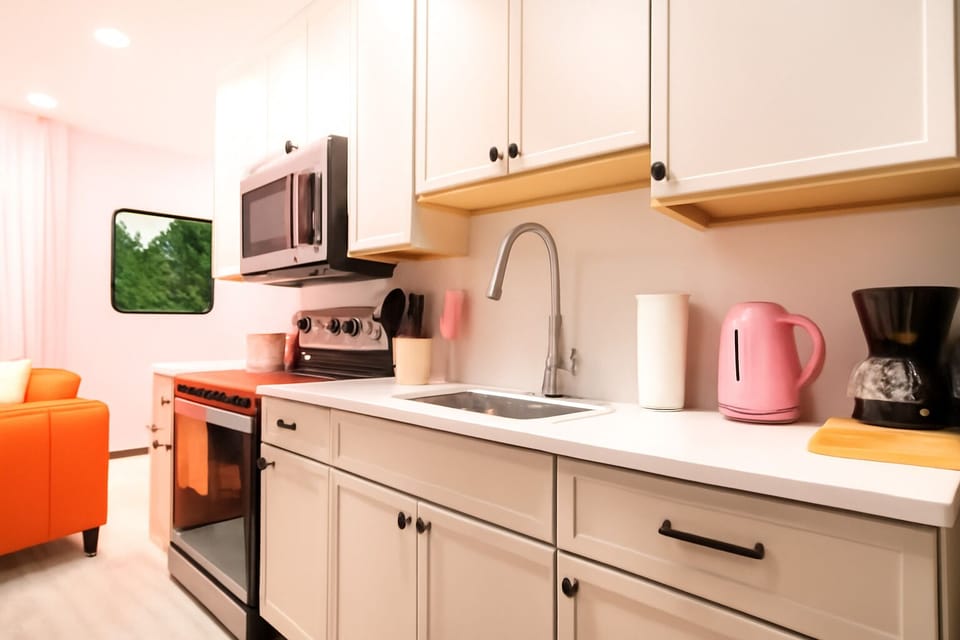 Fully equipped for your stay, complete with modern appliances in a pink aesthetic.