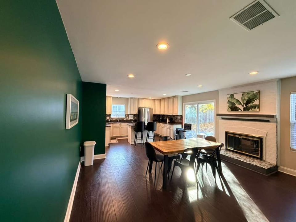 Spacious dining area with a sturdy wooden table and cushioned chairs, offering plenty of room for shared meals and evening board games.