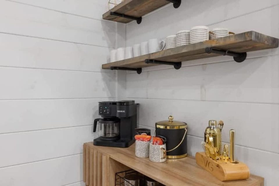 Charming coffee bar with Keurig, mugs, and gold-accent bar
