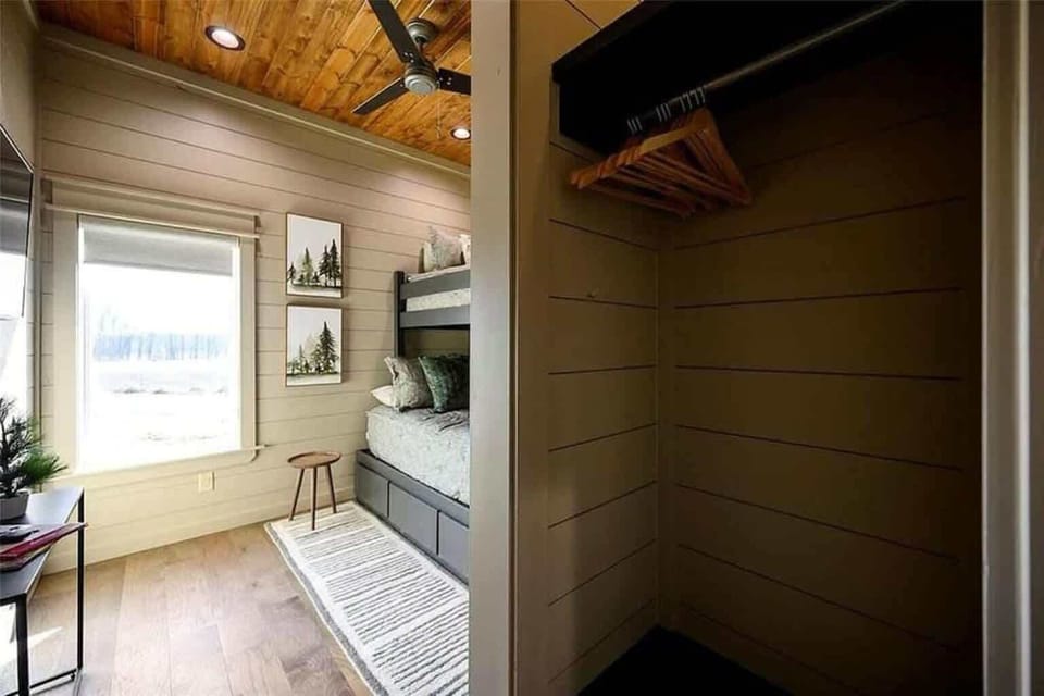 Bright bunk room with built in closet cozy bedding and natural light 