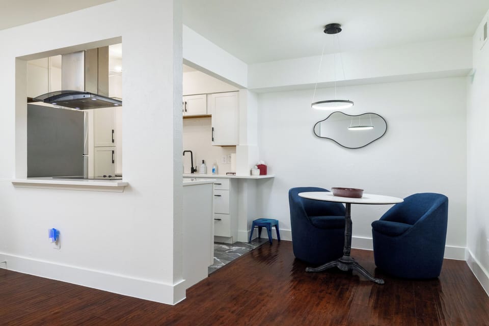 A cozy dining nook with plush navy chairs and a modern round table seating 2.