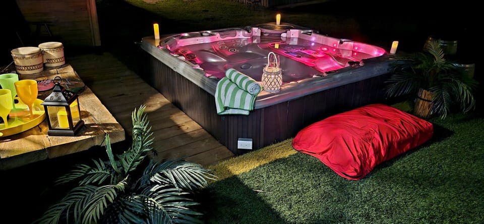 An outdoor spa illuminated in red, offering a relaxing and romantic atmosphere in the evening.