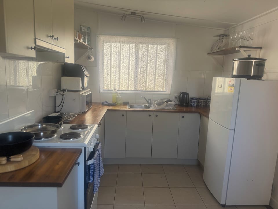 Kitchen with fridge/freezer, stove, oven, microwave, crockery, utensils, cutlery