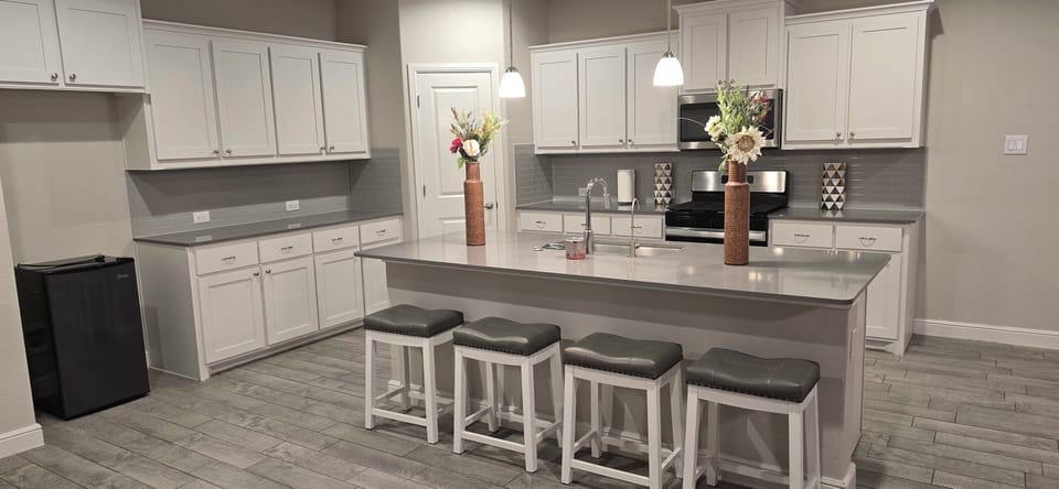 Full open kitchen with 4 bar stools for breakfast area and a large island