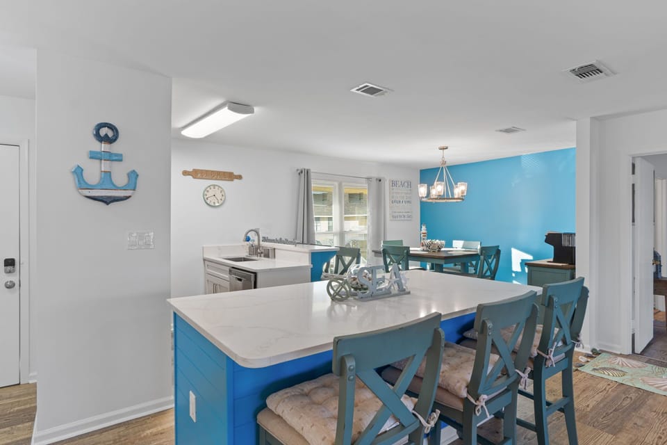 Your bright coastal kitchen invites you to create memorable meals with its spacious island, charming nautical touches, and cheerful blue accents.