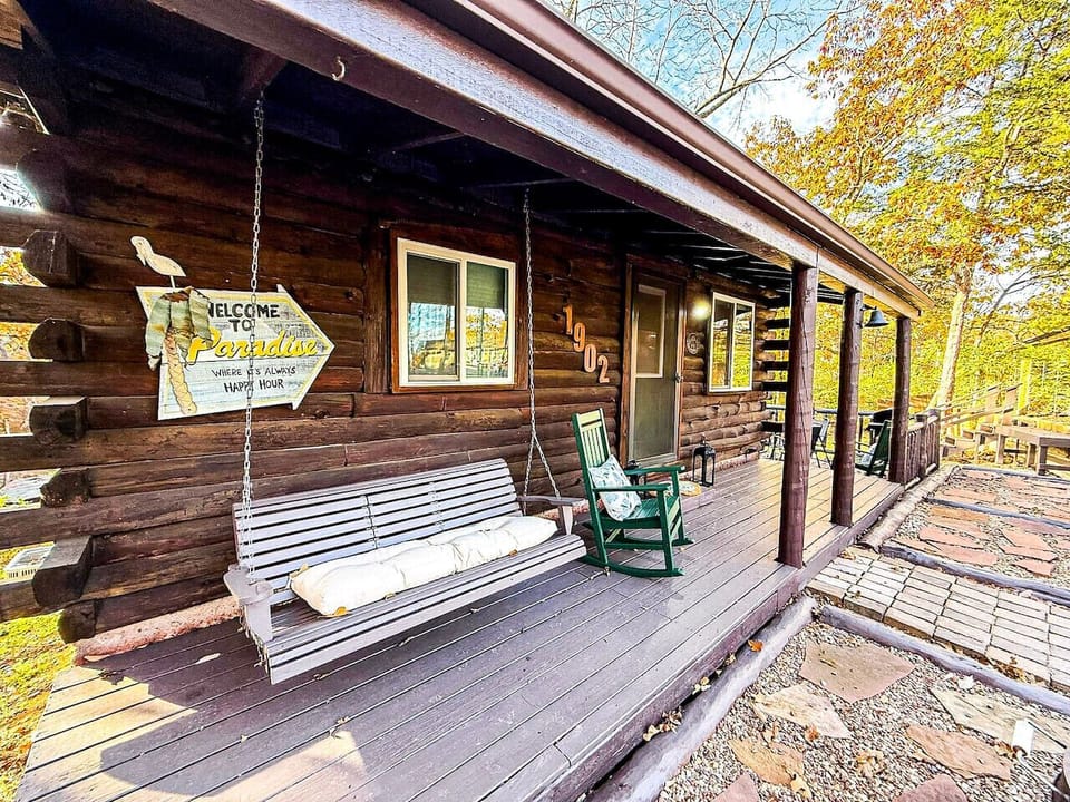 Rocking chairs and a swing overlooking peaceful wooded surroundings.