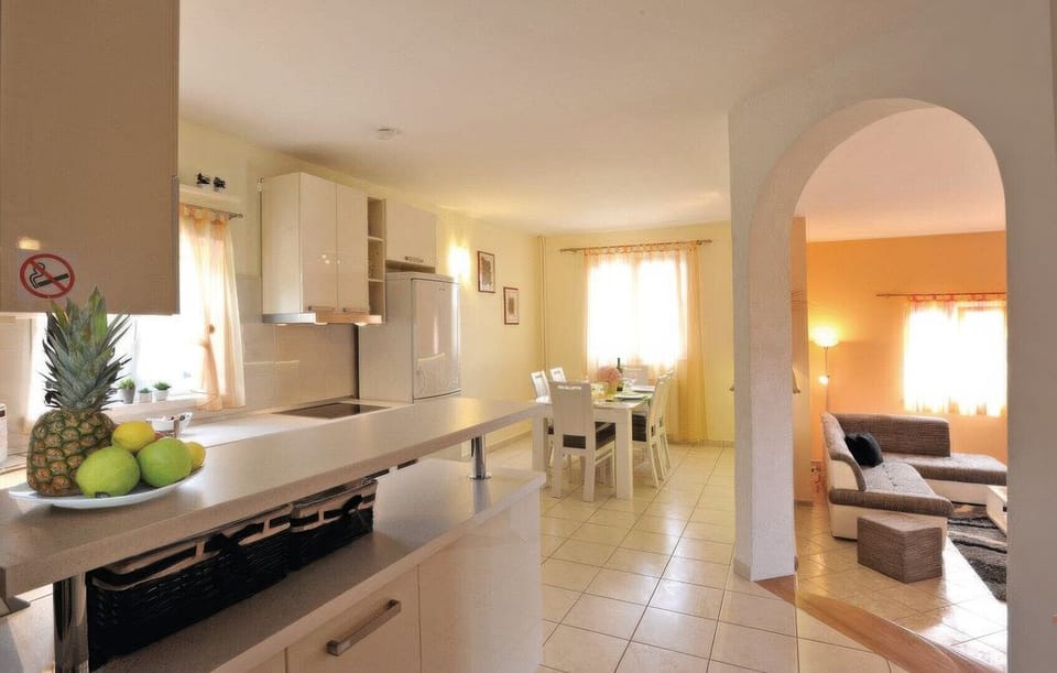 The kitchen and dining area of one apartment are bright and airy, opening up through an archway into the separate, adjacent living room.