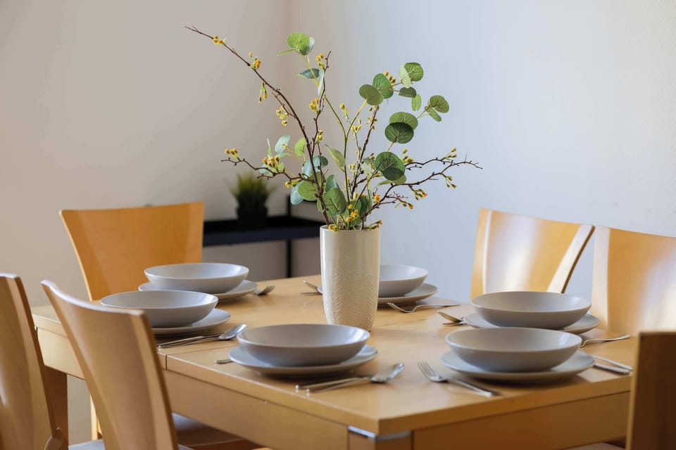 A table decorated with fresh flowers and elegant tableware invites you to share meals in a warm ambiance.