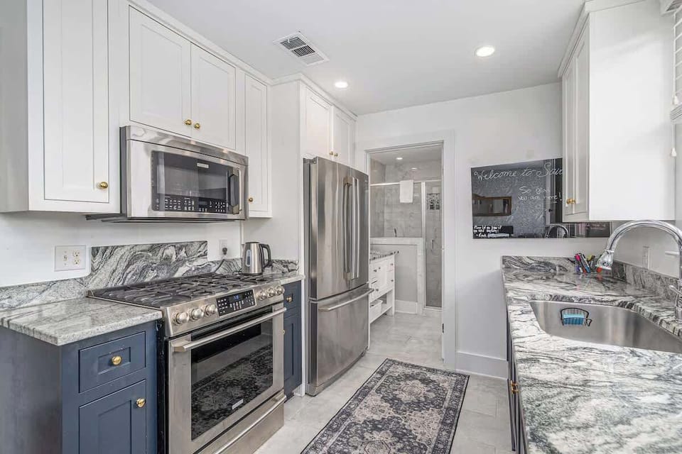 This stylish kitchen makes the most of its space — pairing bright coastal colors with sleek, dark marble countertops for a beautiful balance.