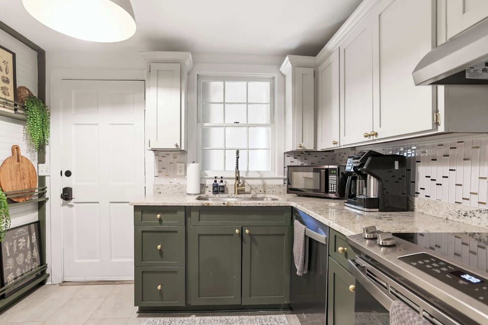 The bright kitchen opens directly to the shared patio through a back door, filling the space with natural light and offering easy indoor-outdoor living in downtown Savannah.