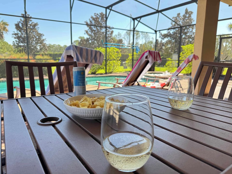 Enjoy crisp white wine and snacks on your private screened patio, overlooking the sparkling pool