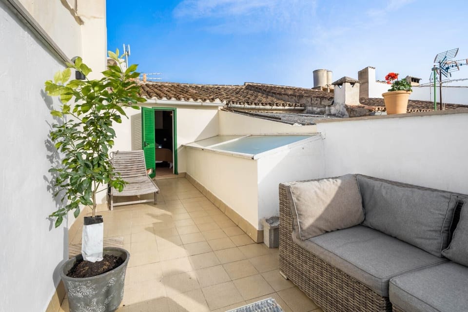 Cosy private terrace with a seating area, sun loungers and views over the traditional village rooftops, ideal for relaxing outdoors.