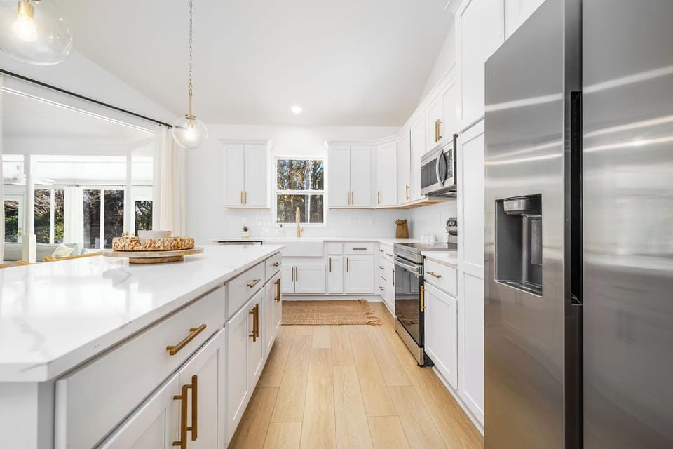 Stainless steel appliances and a window to the pool and deck