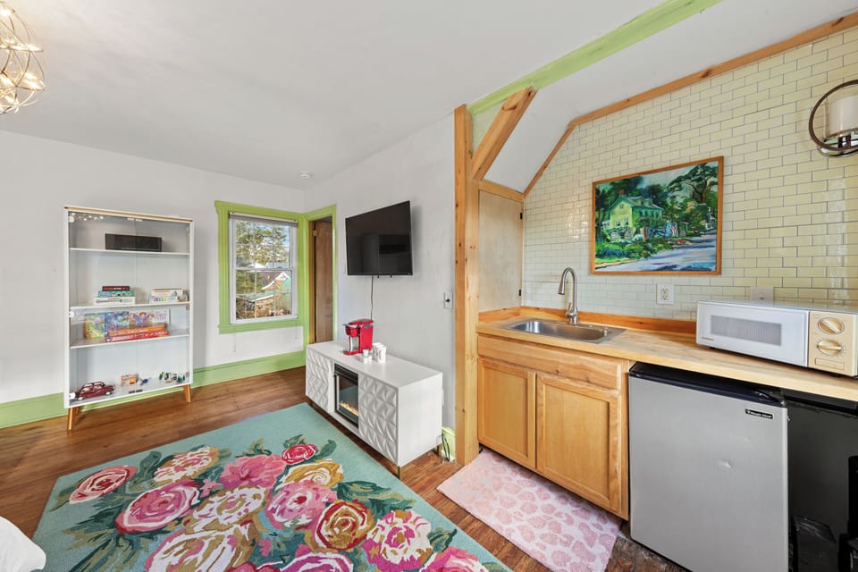 Mini-kitchen has a small refridgerator, microwave and a kuerig. 