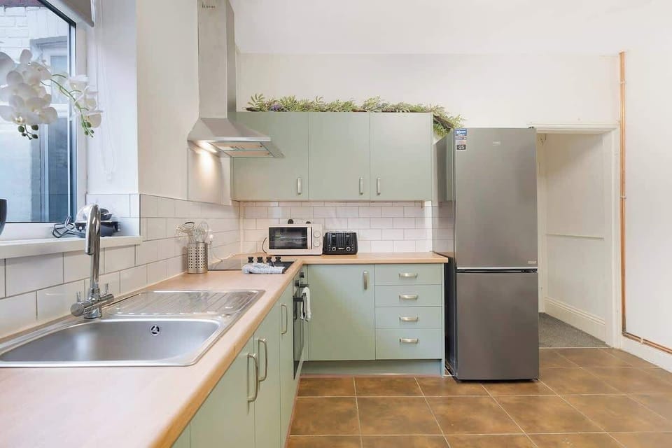 Kitchen equipped with all essentials, including an oven, fridge, and full cookware set.