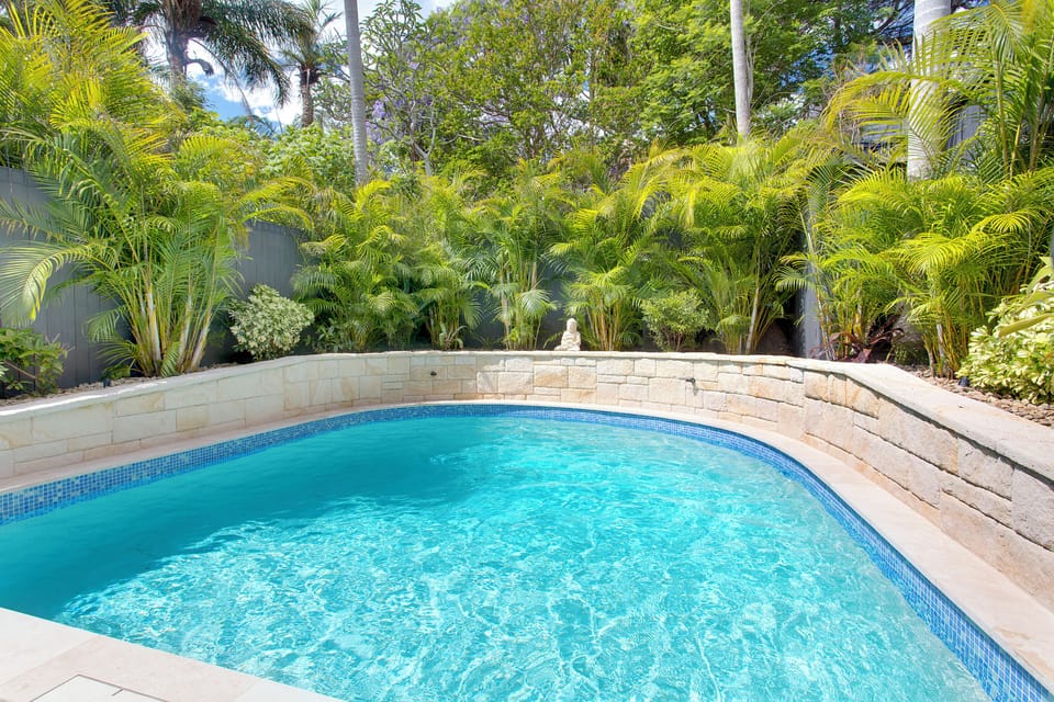 Fully fenced in-ground pool, with stairs.