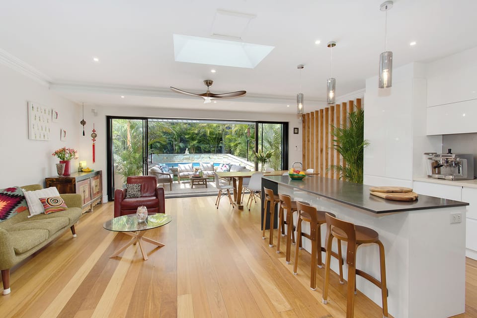 Open plan kitchen, living space, and dining flows to backyard