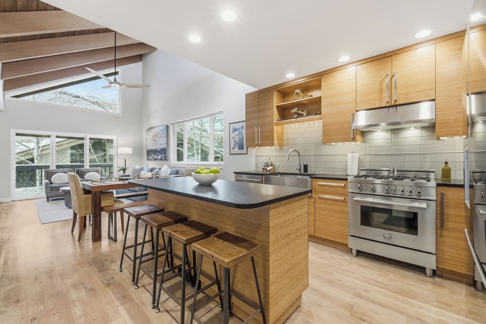 Open living area with vaulted ceilings, modern kitchen, and cozy seating