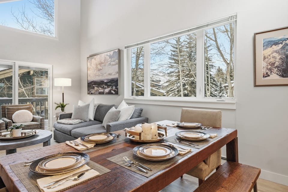Dining table set for shared meals, framed by natural light and mountain views