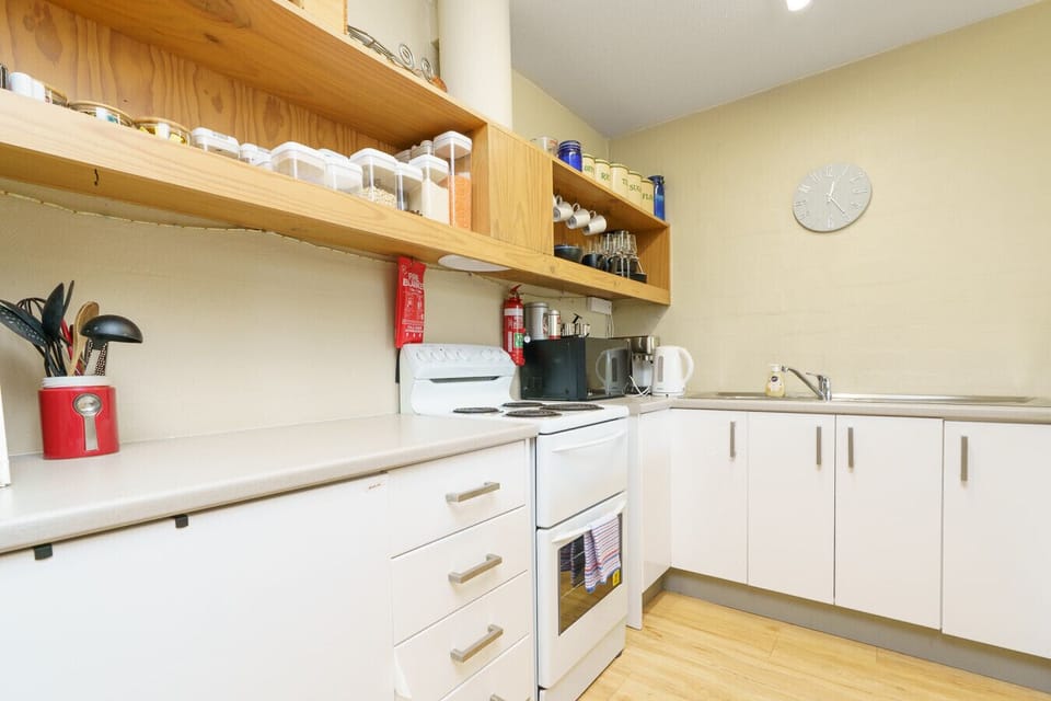 A well-equipped kitchen with clean white cabinetry, timber accents, and everything you need for easy home cooking