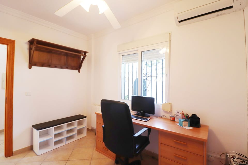 Ground-floor room with views of the terrace and air conditioning. It includes a desk and an ergonomic chair, ideal as a workspace or reading area. Very bright and cozy.