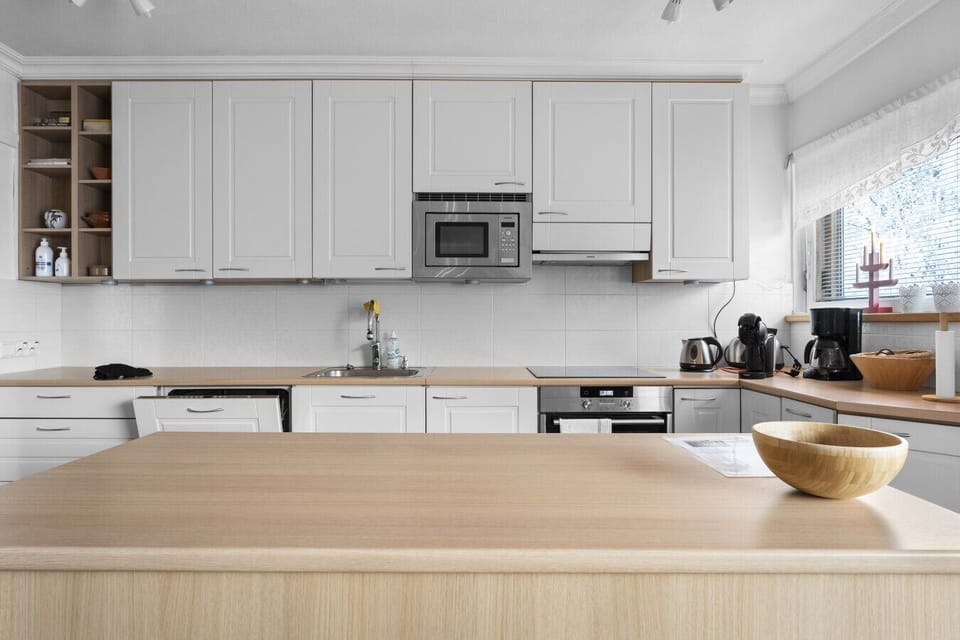 The kitchen is fully equipped with an induction cooktop, oven, microwave, dishwasher, and all necessary small appliances like a coffee maker and electric kettle.