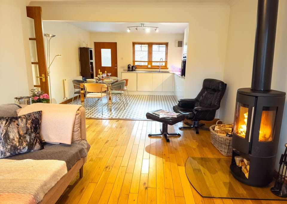 Spacious lounge with plenty of light and warmth, ideal for dog-friendly Highland evenings.
