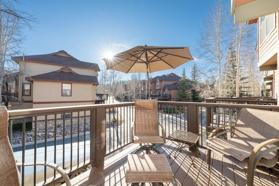Relax on your private deck with mountain air and sunshine, featuring comfortable seating and an umbrella for perfect outdoor moments.