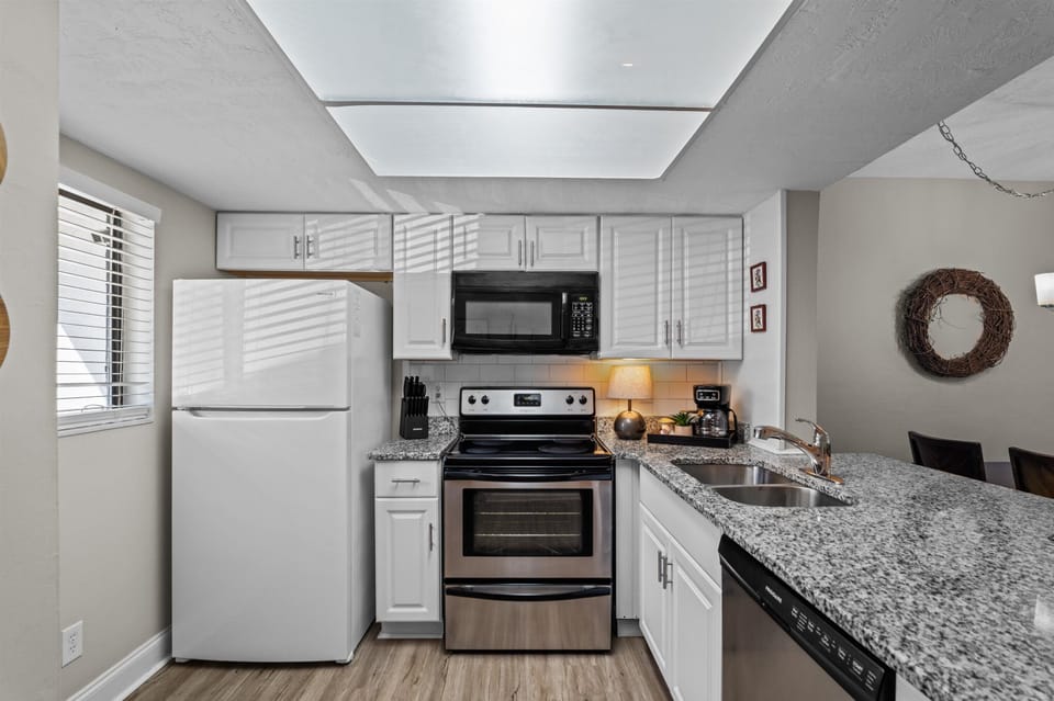 fully equipped kitchen with granite countertops and counter-height