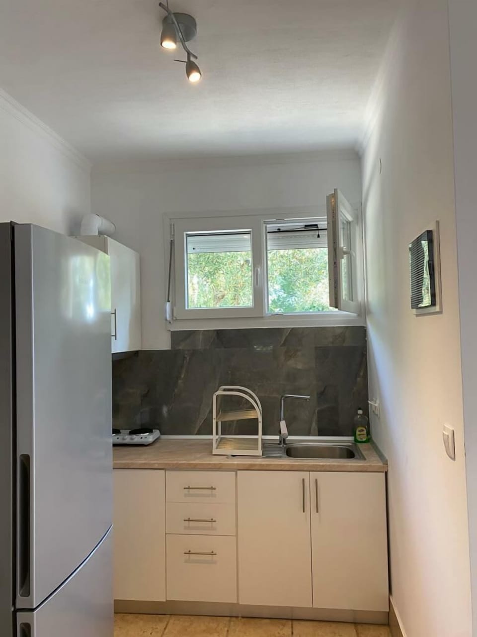 Prepare your favorite meals easily in this practical kitchen featuring heating plates, fridge, and all essential utensils.